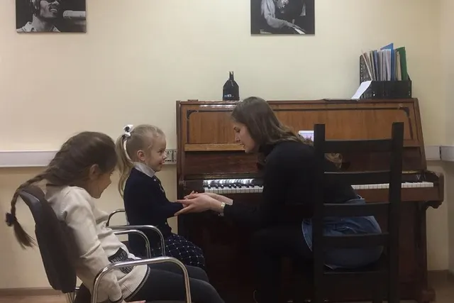 Дети на уроке в классе с фортепиано